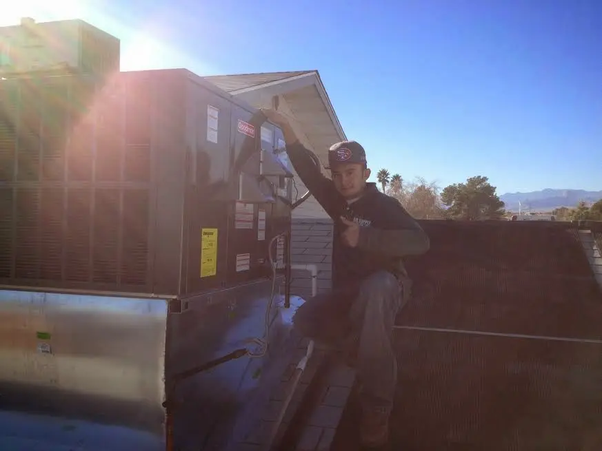HVAC technician performing Air Duct Repair on a rooftop unit in University of Virginia